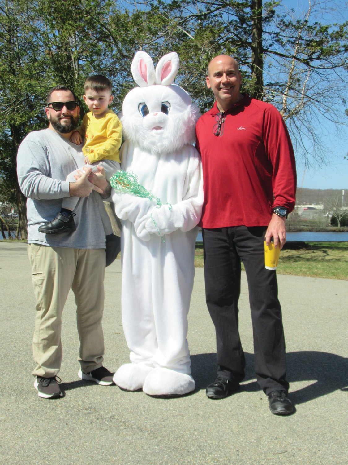 BUNNY’S BUDDIES: Joseph Moscarelli and his son Julian, 3, and Johnston Parks and Recreation Director Chris Correia enjoy lighter moment with the Easter Bunny during last week’s special Bunny Walk inside War Memorial Park.